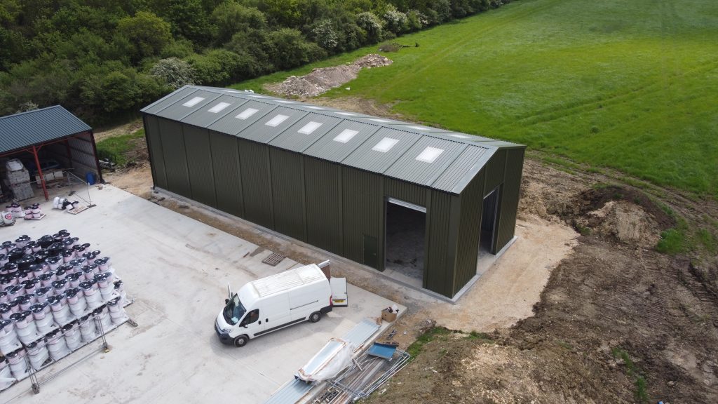 Long green steel storage building with rooflights in Oxfordshire, manufactured by Saredon Steel Buildings Ltd