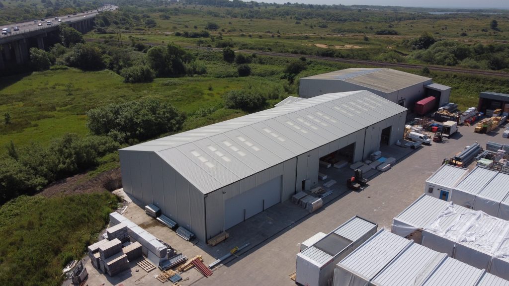 Large steel industrial warehouse with multiple loading bays in Kenfig, manufactured by Saredon Steel Buildings Ltd.